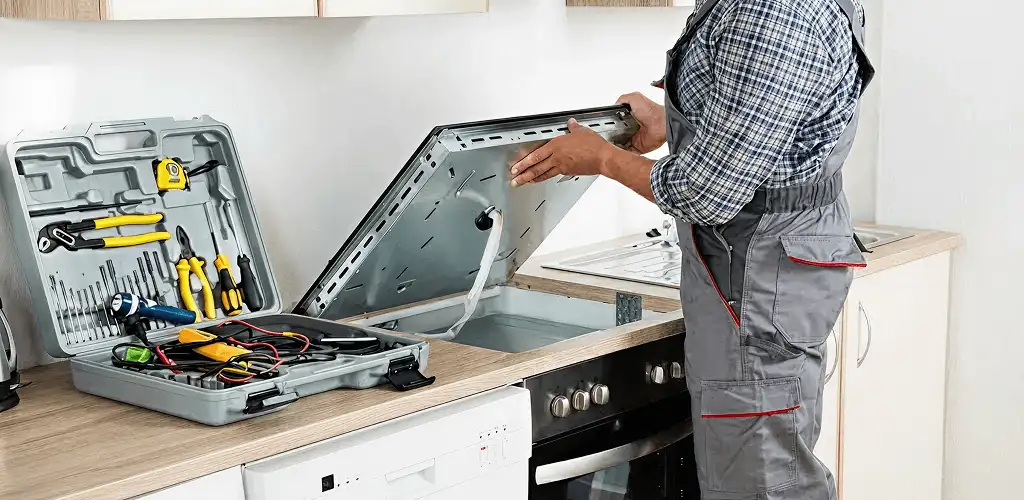 Handyman repairing a cooktop and checking wiring connections in Buffalo, NY