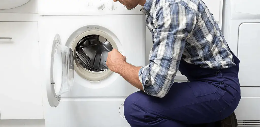 Handyman inspecting a dryer drum and internal parts for repair in Buffalo, NY