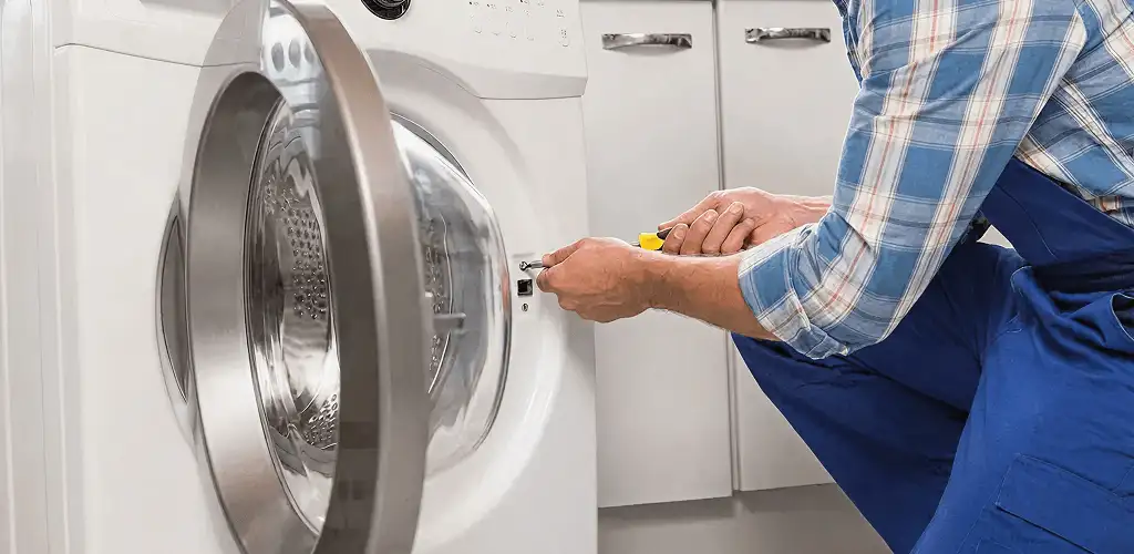 Handyman repairing a clothes dryer and checking electrical connections in Buffalo, NY