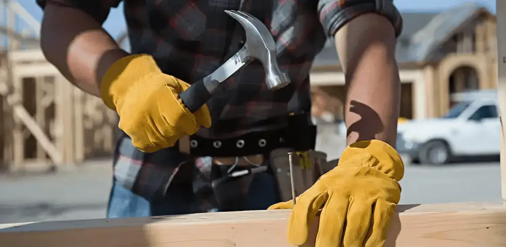 Handyman fixing wood trim with a hammer for home repairs in Buffalo, NY