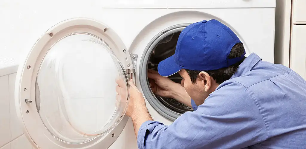 Washing machine repair handyman inspecting a front-load washer drum in Buffalo, NY