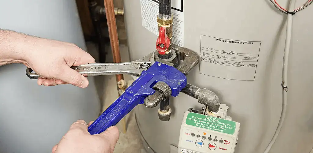 Water heater repair technician tightening the shutoff valve and supply line in Buffalo, NY